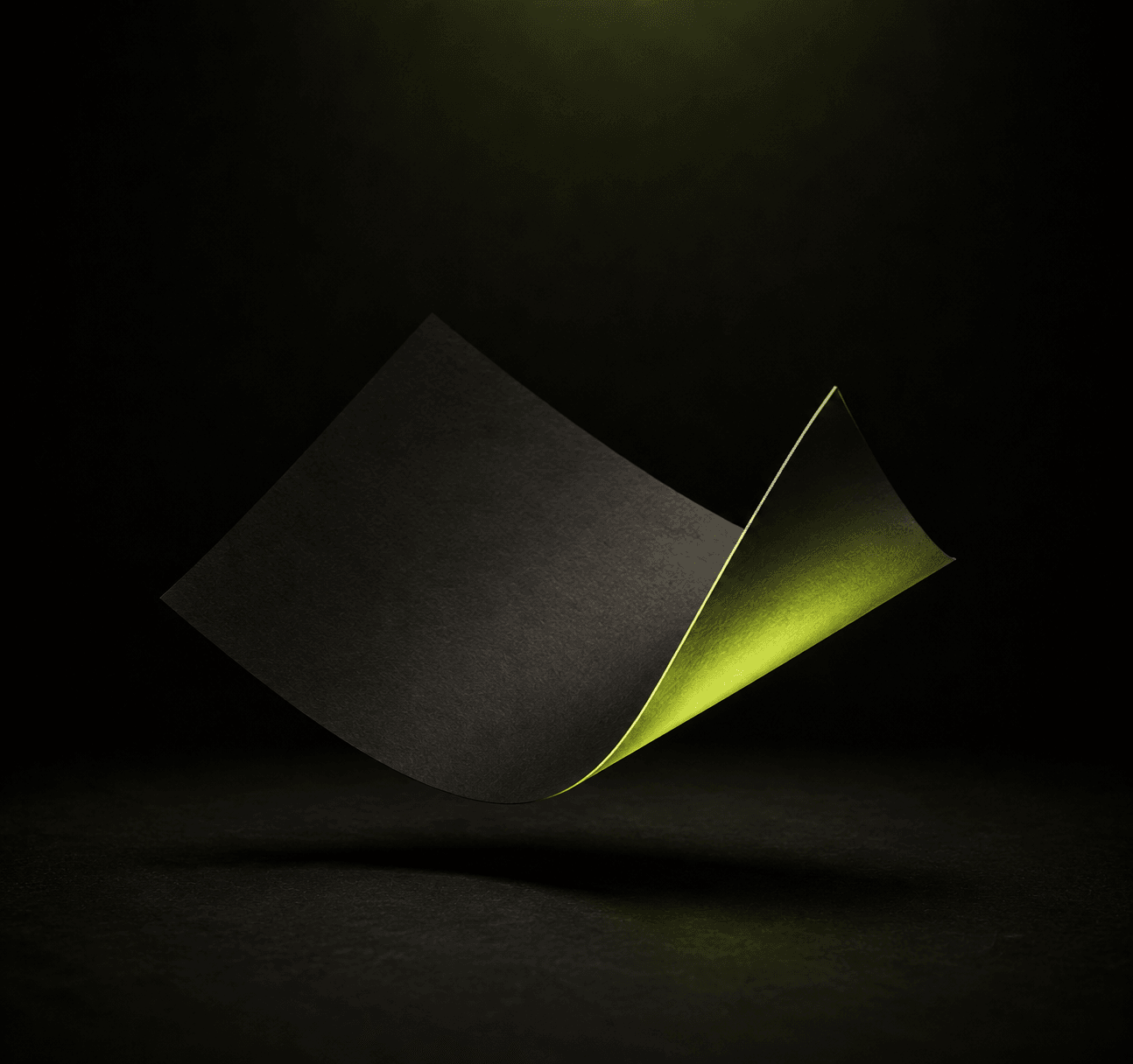 A sheet of black paper curling in mid-air over a lime underside